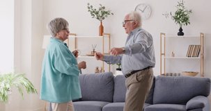 Happy senior married couple, wife and husband, dancing together at home. The music playing in the background sets the mood for dance, showcasing love and affection for each other. - Powered by Shutterstock - Get 15% off with code: PIKWIZARD15