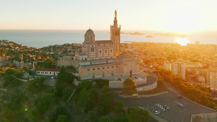 Aerial view of the Notre Dame de la Garde or Our Lady of the Guard church at sunset, southern France. The warm summer evening light illuminates the Marseille cityscape. 