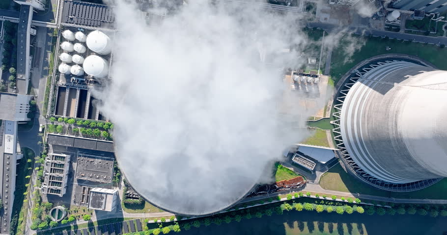 Aerial view of steam rises from the huge chimneys of the operating power plant