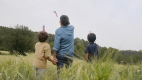 back view of mother and sons  with usa flag on field. 4th july independence day. - Powered by Shutterstock - Get 15% off with code: PIKWIZARD15
