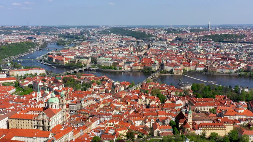 View of Prague featuring vibrant rooftops on a sunny day in summer. Aerial view of Prague, Charles Bridge over Vltava river in Prague, Czechia. Old Town of Prague, Czech Republic.