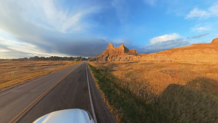 Unidentified car drives through, Badlands National Park, South Dakota, USA