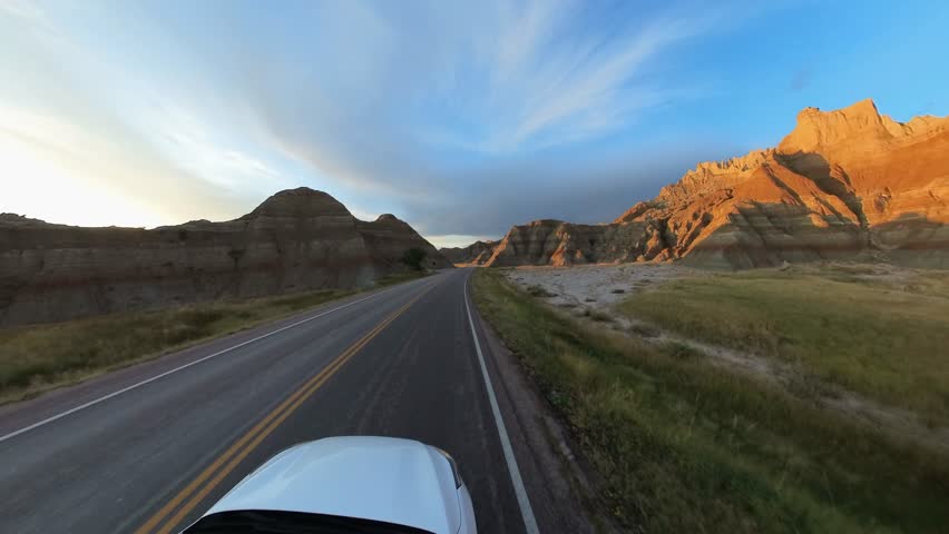 Unidentified car drives through, Badlands National Park, South Dakota, USA