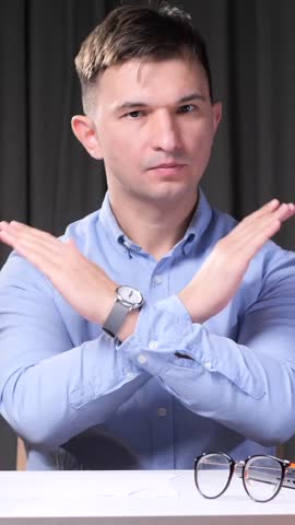 vertical video Businessman making stop sign with crossed arms in office