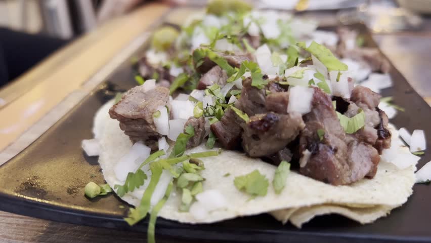 Close-up of a delicious street taco with beef, onion, and herbs on a plate