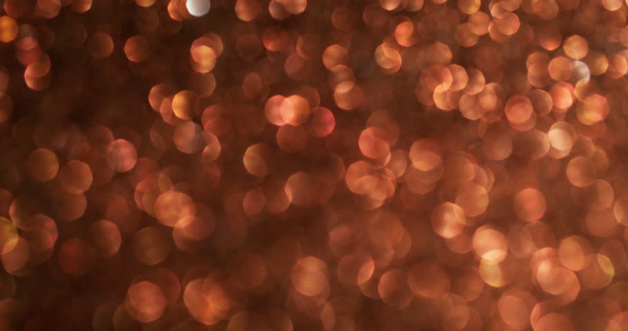 Blurred shimmer. Orange flare. Iridescent twinkle color atmospheric shiny surface with uneven glitter effect glowing sparkling circle spots.