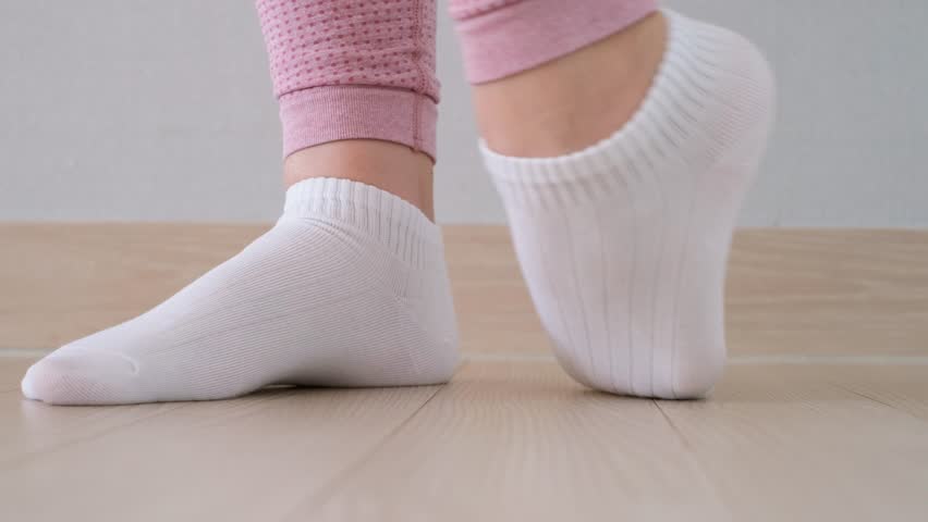 Female legs doing exercises and stretching feet front view.