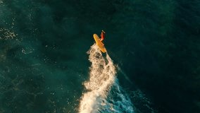 Top down view of the woman surfing the wave. Aerial view of the female surfer riding the wave in the Maldives - Powered by Shutterstock - Get 15% off with code: PIKWIZARD15