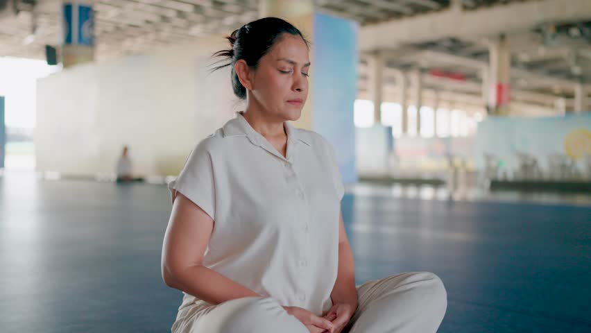 Moment of Reflection. A woman stands in a spacious, light-filled interior, eyes closed, lost in quiet contemplation. Her posture suggests a sense of peace and serenity.