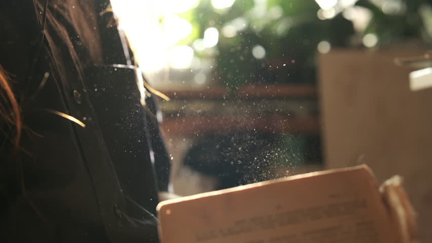 Close up, home interior, cinematic. vintage old book in girl's hand, dust. slow motion