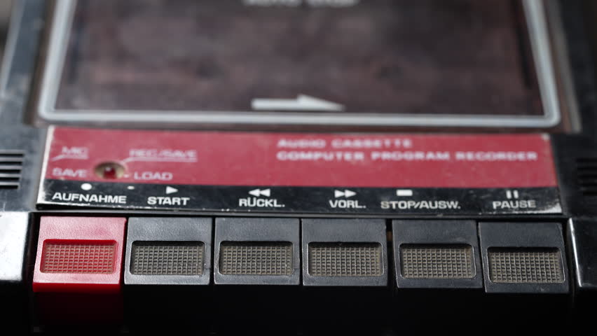 Finger presses buttons on an old vintage cassette recorder, play, stop, rec. Tape recorder control, push the control buttons on the tape recorder with your finger. Audio cassette recorder very old
