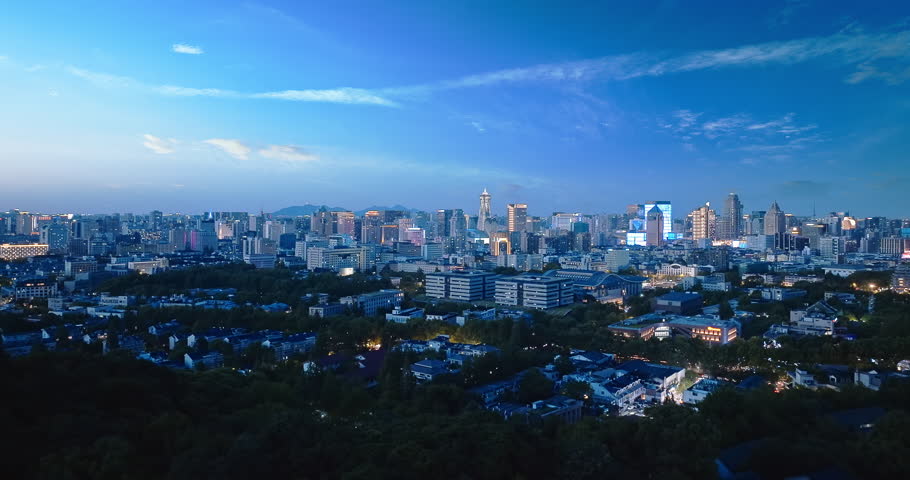 Aerial shot of modern cityscape of downtown buildings and lake at dusk in Hangzhou, China