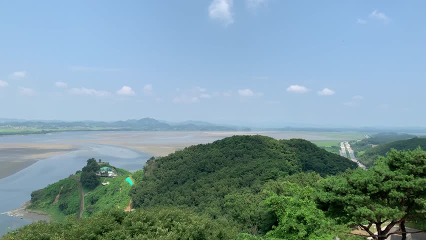 South Korea and North Korea border in the middle of Han and Imjin rivers. DMZ zone. Low tide. View from Odusan Unification Observation Deck. Movement of cars on a highway on  South Korean side