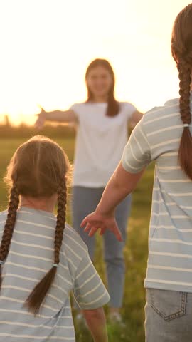 Family reunion field, Children running mom, Outdoor fun during sunset, Happy family moments, Summer evening joy, Kid mom embrace, Warm sunset nature, Family bonding time, Scenic outdoor playtime.