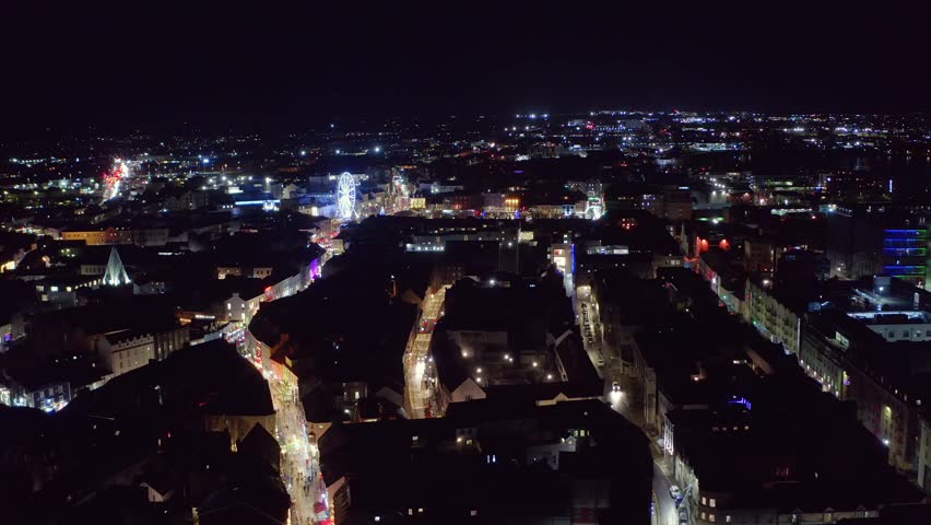 Vast aerial view of Galway city at night, featuring Shop Street and Eyre Square Market