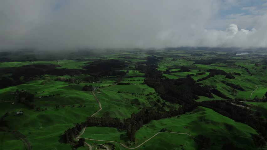 Aerial above scenic green hill landscape above the clouds in Malaysian countryside.