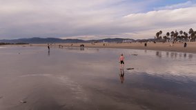 A joyful girl plays on the beach, performing a handstand in the waves - Powered by Shutterstock - Get 15% off with code: PIKWIZARD15