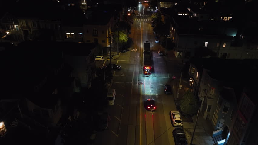 Aerial view followng a light rail on the illuminated streets of San Francisco