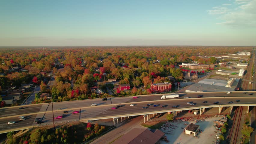 Tracking a dry van semi-truck on I-70 in Indianapolis, Indiana, with suburban homes and autumn foliage in the background.