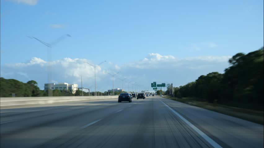 First person point of view looking out the windshield of a car traveling south on I-95 through Palm Beach County in a high-speed time-lapse