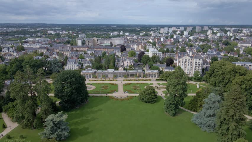 Amazing panoramic drone movement backwards towards the botanical garden of Parc du Thabor and citsycape, Rennes, Bretagne in France.