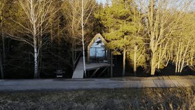 Forest glamping cabin on elevated platform, featuring glass windows and terrace - Powered by Shutterstock - Get 15% off with code: PIKWIZARD15