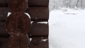 Snow falls in slow motion against a wall of logs. Snowy weather. Slowly falling snowflakes. A magical sight. Natural beauty and tranquility. Snowfall in the village. - Powered by Shutterstock - Get 15% off with code: PIKWIZARD15