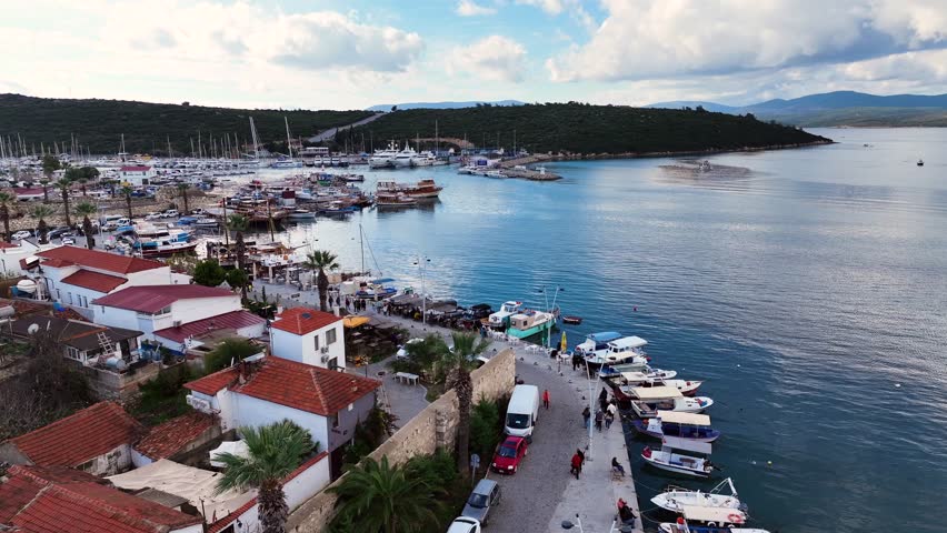 Aerial high-quality view of the historical castle, fishing port, coastline and historical village houses of Izmir tourist village Sığacık
