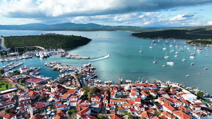 Aerial high-quality view of the historical castle, fishing port, coastline and historical village houses of Izmir tourist village Sığacık
