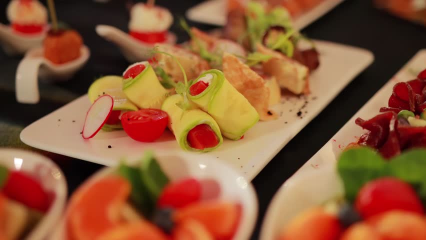 Zucchini rolls with tomato and feta cheese in a restaurant, close-up. Slow motion