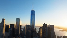Sunrise over One World Trade Center bathes New York City skyline in golden light. Financial District of Lower Manhattan urban scenery during golden hour - Powered by Shutterstock - Get 15% off with code: PIKWIZARD15