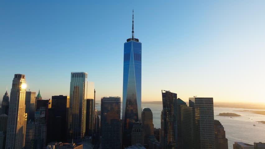 Aerial view of the One World Trade Center dominating New York City skyline. Warm golden tones of sunrise in Financial District of Lower Manhattan