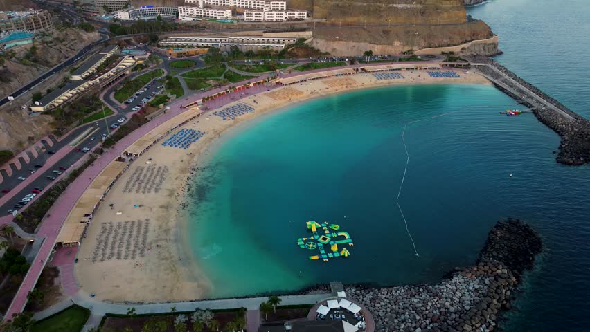 Calm, crystalline water and golden sand bay with leisure activities.