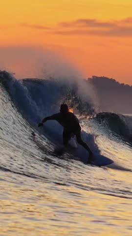 Video of young adult surfs in ocean at evening time
