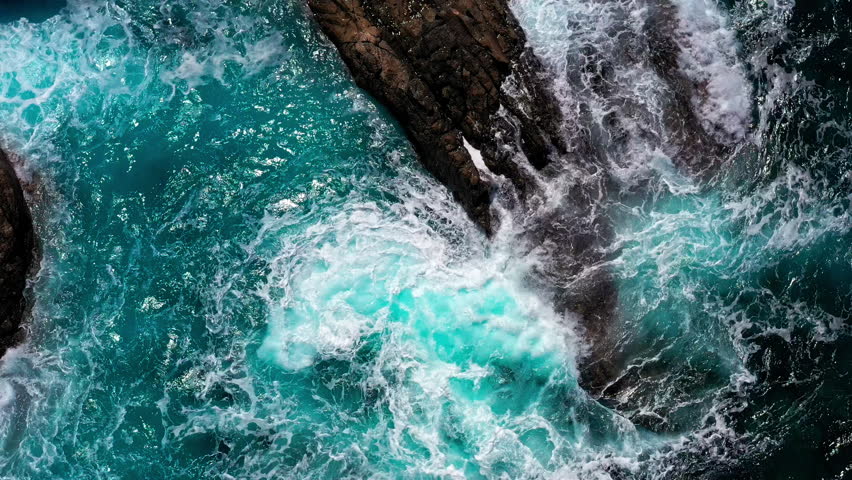 Turquoise Ocean Waves Crashing Against Dark Volcanic Rocks in Aguas Verdes, Fuerteventura. Dramatic Aerial View of Powerful Sea Meeting Rugged Coastline in Canary Islands