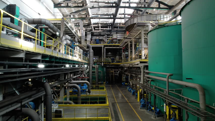 Premise of cardboard production plant workshop with mechanisms. Special work equipment of pipes and tanks provides capacity to create material from paper pulp