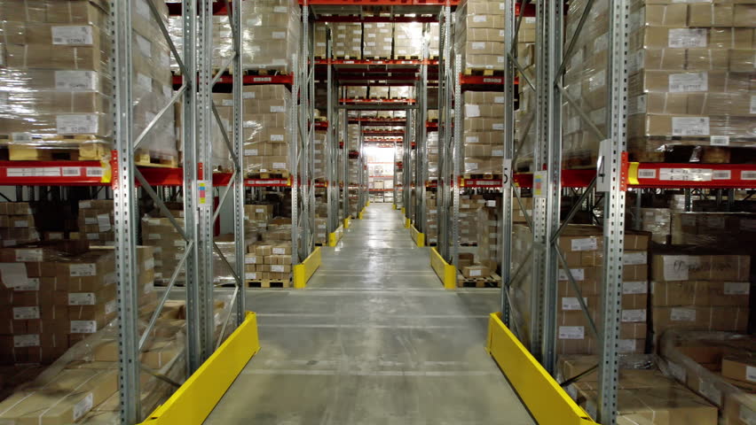 Cardboard plant warehouse aisle with finished products on shelves. Tall structures provide compact storage of materials in form of boxes