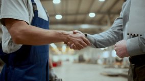 Male worker in overalls shaking hands and talking to engineer during meeting in industrial factory. Close-up view - Powered by Shutterstock - Get 15% off with code: PIKWIZARD15