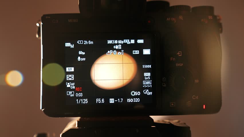 Professional studio for photo and video production filming with modern equipment, close up of details, photographer puts on lens on camera, display pov.