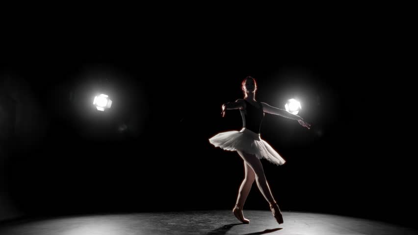 Fascinating ballet performance, beautiful ballerina jumping on dark stage. Beautiful and passionate woman in white tutu dancing by classical music, professional ballet dance performer, art and hobby