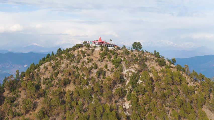 Aerial drone shot of a hindu temple on top of the mountain in uttarakhand