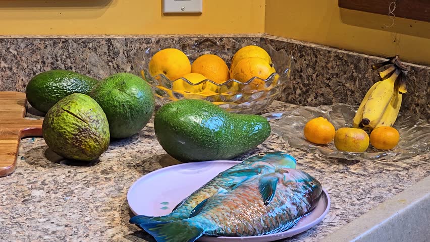 Colorful parrotfish on a kitchen counter with fruits, vibrant and fresh