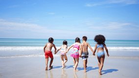 Happy Children travel playing at the sea on summer beach holiday vacation. Group of Little cute child boy and girl kid enjoy and fun outdoor lifestyle running and playing in the sea at tropical island - Powered by Shutterstock - Get 15% off with code: PIKWIZARD15