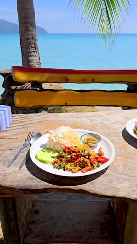 Indulge in a culinary delight Phat kaphrao Thai food, overlooking the turquoise waters of Koh Kood, Thailand. Fresh ingredients and vibrant flavors make this meal unforgettable, 