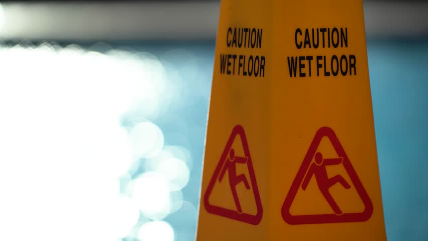 Sign caution slippery floor on sea background bokeh