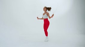 Young woman with a skipping rope on a white background. - Powered by Shutterstock - Get 15% off with code: PIKWIZARD15