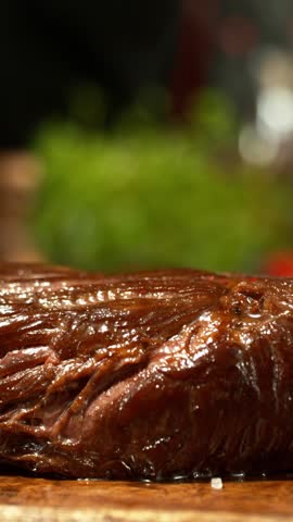 Super Slow Motion of Flying Salt no Raw Beef Steak. Camera Placed on High Speed Cine Bot. Chef is Pouring Salt on the Meal. Filmed on High Speed Cinema Camera, 1000 fps.