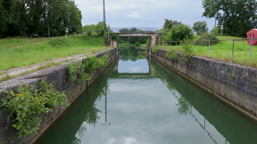 Stenay, FRANCE - DECEMBER 12, 2024: Traveling shot on the canal in Stenay towards the Meuse, verdant scene.