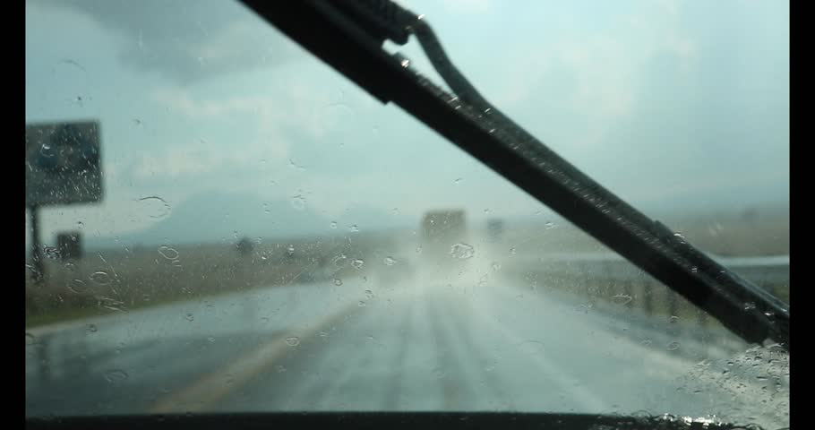 DRIVING ON A VERY RAINY DAY ON THE ROAD WITH THE WINDSHIELD WIPERS ON