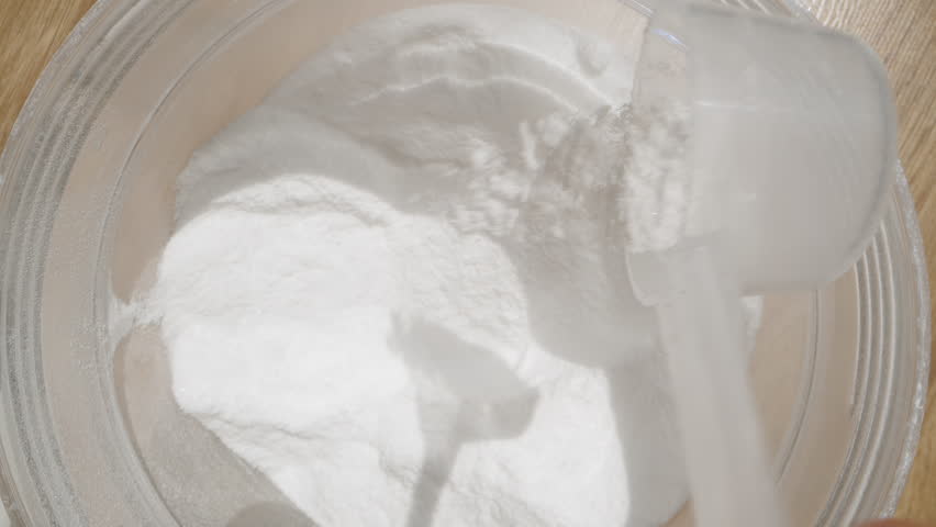 Pouring Creatine back into the container, adjusting the amount for the correct intake.